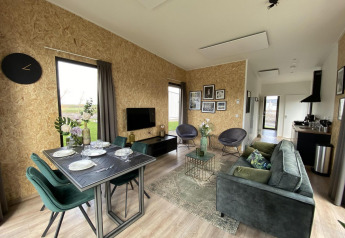 Moderne lodge Just Nature Light ved IJsseløerne i Holland, med stilfuld stue, spisebord og køkken.