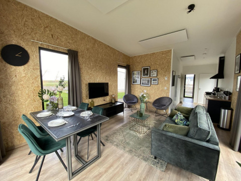 Interno moderno della lodge Just Nature Light alle Isole IJssel, Paesi Bassi, con soggiorno e zona pranzo.