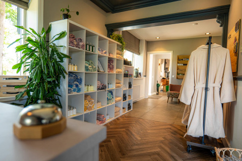 Ingang van de spa bij Hofparken Wiltershaar met badjas, handdoeken, schappen en planten in Gelderland.