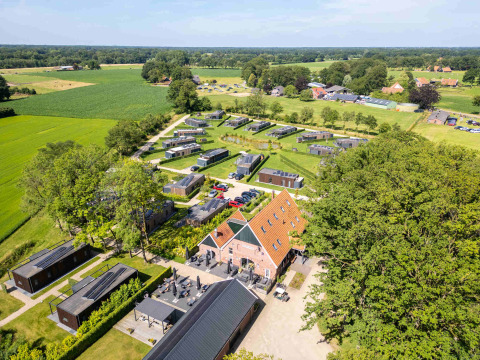 Vista aérea del parque vacacional Hofparken Wiltershaar rodeado de campos verdes en Gelderland, Países Bajos.