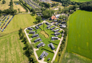 Aerial view of Hofparken Wiltershaar holiday park with modern cabins and green fields in Gelderland, Netherlands.