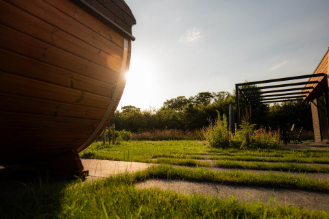 Coucher du soleil sur l'herbe au parc de vacances Hofparken Wiltershaar à Gelderland, Pays-Bas, avec cabane en bois.