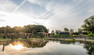 Blick auf Ferienhäuser, Saunen und einen natürlichen Schwimmteich im Hofparken Wiltershaar, Gelderland.