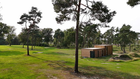 Casa vacanza moderna in legno circondata da alberi e prato a Hofparken De Bergvennen, Overijssel, Paesi Bassi.