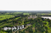 Luftfoto af Hofparken De Bergvennen feriepark i Overijssel, Holland, med grønne marker og træer.