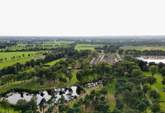 Luftfoto af Hofparken De Bergvennen feriepark i Overijssel, Holland, med grønne marker og træer.