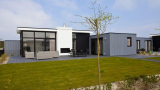 Alojamiento moderno en L-Cube 6 en Schoneveld, Países Bajos, con grandes ventanales y terraza con césped.