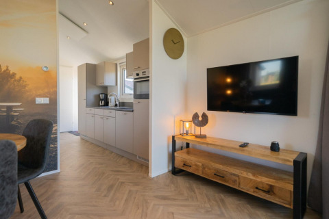 Modernes Velthorst-Lodge-Interieur an den IJsselinseln, Niederlande, mit Küche, Fernseher und Holzmöbeln.