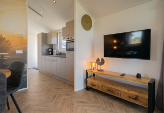 Modernes Velthorst-Lodge-Interieur an den IJsselinseln, Niederlande, mit Küche, Fernseher und Holzmöbeln.
