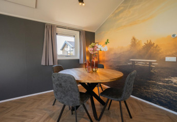 Eethoek met ronde tafel, vier stoelen en natuurwand in de Velthorst-lodge op de IJssel-eilanden, Nederland.