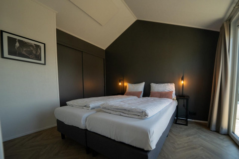 Dormitorio moderno con camas gemelas en el lodge Velthorst en las Islas IJssel, Países Bajos, con elegante decoración.