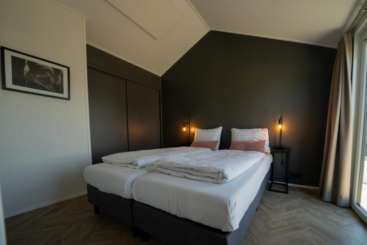 Chambre moderne avec lits jumeaux au lodge Velthorst sur les Îles IJssel, Pays-Bas, décor élégant et lumineux.