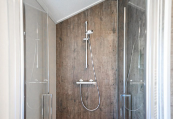 Moderne douche in lodge Velthorst op de IJssel Islands in Nederland, met glazen deuren