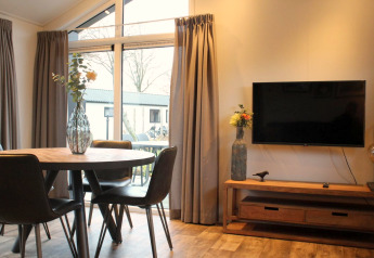 Salon moderne dans la tiny house Berkel aux IJssel Islands, Pays-Bas, avec TV et table ronde en bois.