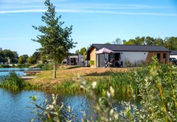 Tiny house Berkel aux IJssel Islands, Pays-Bas, au bord d'un lac, avec des gens profitant du plein air.