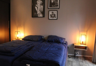 Camera da letto della tiny house Berkel alle IJssel Islands, Paesi Bassi, con due letti e illuminazione calda.