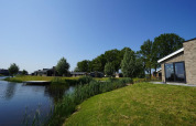 Vista de la casa Hackfort en The IJssel Islands, Países Bajos, cabañas junto al lago y cielo despejado.