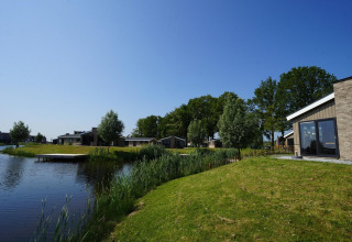 Vista de la casa Hackfort en The IJssel Islands, Países Bajos, cabañas junto al lago y cielo despejado.