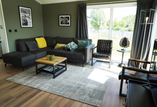 Soggiorno moderno in un lodge Hackfort alle IJssel Islands, Paesi Bassi, con grandi finestre ed arredi accoglienti.