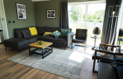 Soggiorno moderno in un lodge Hackfort alle IJssel Islands, Paesi Bassi, con grandi finestre ed arredi accoglienti.