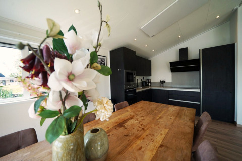 Moderne keuken en eetruimte in Hackfort-lodge op de IJssel Eilanden in Nederland met bloemenvaas.