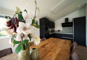 Moderne keuken en eetruimte in Hackfort-lodge op de IJssel Eilanden in Nederland met bloemenvaas.