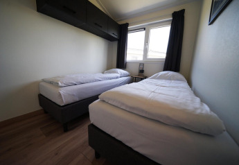 Camera doppia moderna con due letti singoli nella lodge Hackfort alle Isole IJssel, Paesi Bassi.