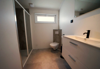Moderne badkamer in Hackfort-lodge op de IJssel Eilanden, Nederland, met douche en wastafel.