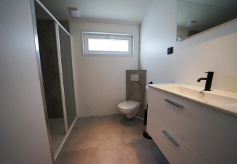 Moderne badeværelse i Hackfort-lodgen på The IJssel Islands, Nederlandene, med bruseniche og vask.