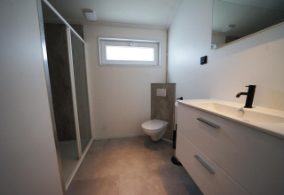 Bagno moderno nella lodge Hackfort alle Isole IJssel, Paesi Bassi, con doccia e lavabo.