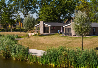 Hackfort-lodge ved The IJssel Islands i Holland, med udsigt over sø og moderne ferieboliger blandt træer.