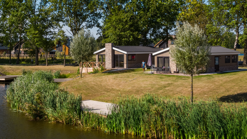 Lodge Hackfort aux IJssel Islands aux Pays-Bas : hébergement moderne au bord du lac, entouré d’arbres.