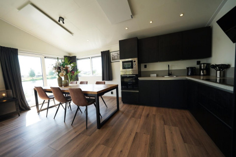 Cuisine moderne et salle à manger avec de grandes fenêtres à la Hackfort Lodge sur les IJssel Islands, Pays-Bas.