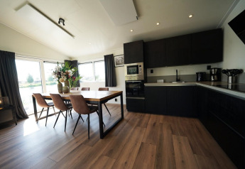 Moderne keuken en eetruimte met grote ramen, genomen in Hackfort Lodge op de IJssel Eilanden in Nederland.