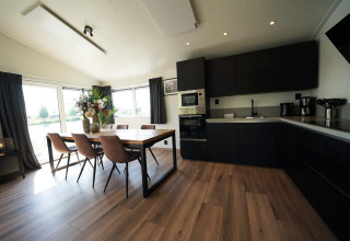 Moderne keuken en eethoek met grote ramen in de Hackfort Lodge op de IJssel Eilanden in Nederland.