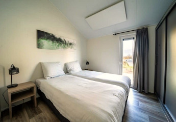 Slaapkamer in Hackfort-lodge op de IJssel Eilanden, Nederland, met twee eenpersoonsbedden en moderne inrichting.