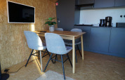 Intérieur moderne au Solo Retreat des îles IJssel, Pays-Bas, avec table à manger, quatre chaises et kitchenette.