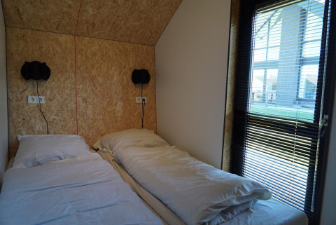 Dos camas individuales con ropa de cama blanca en Solo Retreat en las Islas IJssel en los Países Bajos.
