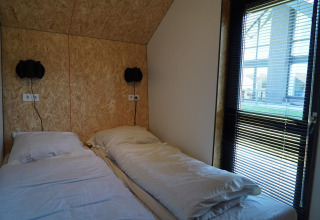 Dos camas individuales con ropa de cama blanca en Solo Retreat en las Islas IJssel en los Países Bajos.