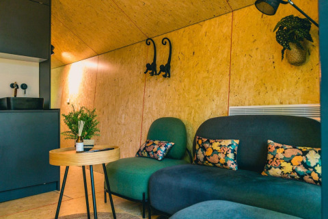 Acogedor salón con muebles modernos y cojines florales en Solo Retreat, IJssel Islands, Países Bajos.