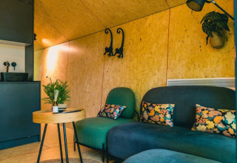 Moderne lounge med farverige puder og grønne planter på Solo Retreat, IJssel Islands, Holland.