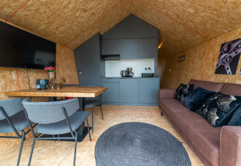 Interiør af Solo Retreat lodge på IJssel Islands i Holland med moderne køkken, spisebord og sofa.