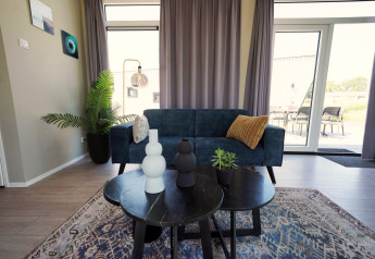 Moderne leefruimte in Just Nature lodge op de IJssel-eilanden, Nederland, met sofa, tafel en decoratie.
