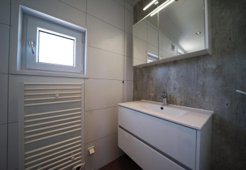 Moderne badkamer in Just Nature, IJssel Eilanden, Nederland, met wastafel, spiegel en venster.