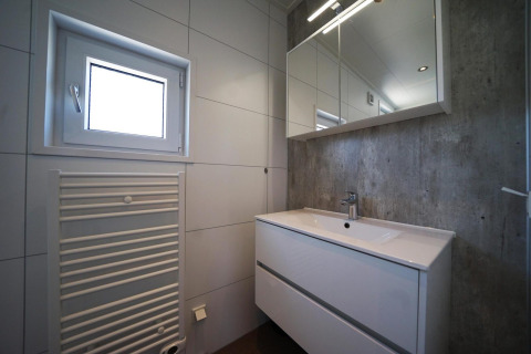 Moderne badkamer bij Just Nature, IJssel Eilanden, Nederland, met wastafel, spiegelkast en raam.