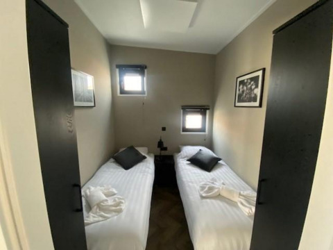 Habitación en Just Nature en las Islas IJssel, Países Bajos, con dos camas individuales y decoración sobria.