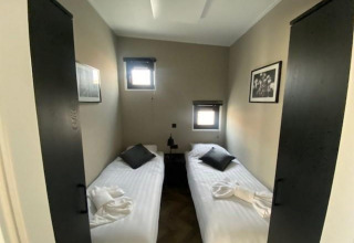 Kamer in Just Nature op de IJssel-eilanden in Nederland met twee enkele bedden en minimalistische stijl.