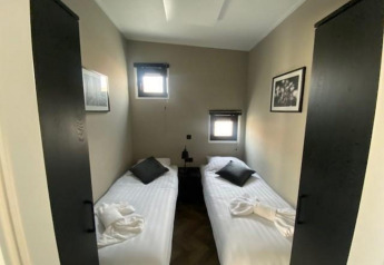 Habitación en Just Nature en las Islas IJssel, Países Bajos, con dos camas individuales y decoración sobria.