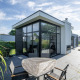 Moderne lodge Cube Exclusif 4 ved Schoneveld i Holland, med store vinduer og terrasse med havemøbler.