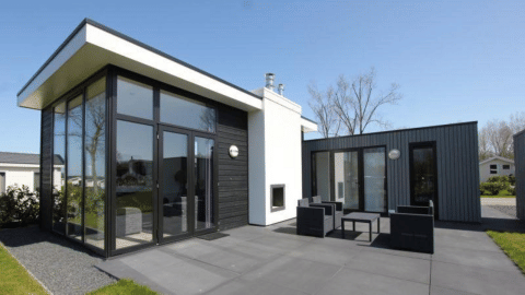Moderno lodge L-Cube a Spaarnwoude, Paesi Bassi, con grandi vetrate, patio e area salotto esterna.